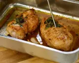 Två saftiga kycklingfiléer i ugnsform, redo för ett strimlad kyckling recept. En termometer mäter temperaturen.