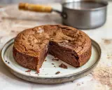 En saftig kladdkaka i kastrull, med en bit borttagen för att visa den härliga chokladkärnan. Perfekt för en fika!