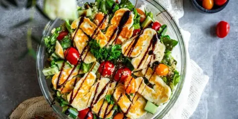 En härlig halloumi sallad med quinoa, körsbärstomater och gurka, ringlad med balsamvinäger. Perfekt för en lätt lunch.