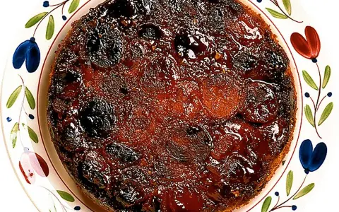 En härlig aprikoskaka upp och ner, med karamelliserad yta och saftiga aprikoser, serverad på en vackert dekorerad tallrik.