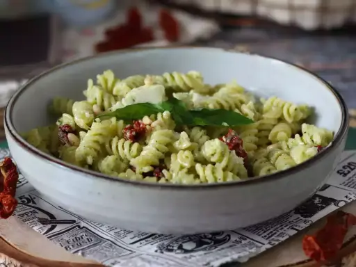 Pastasallad med krämig pesto, pinjenötter, ost och smakrika soltorkade tomater. En härlig sommarrätt.