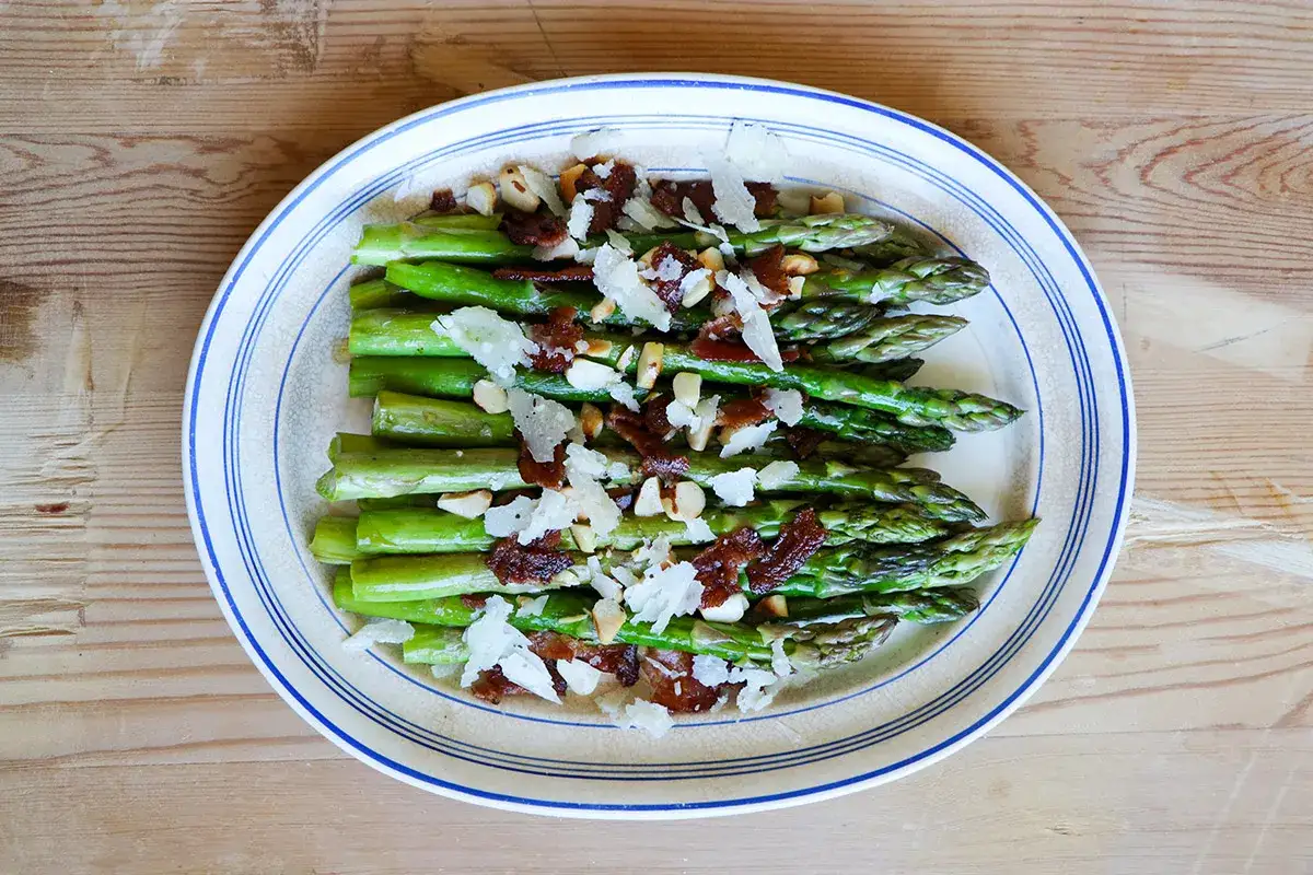 Gr&ouml;n sparris med knaprigt bacon, n&ouml;tter och parmesan. En h&auml;rlig r&auml;tt med baconlindad sparris som passar till det mesta.
