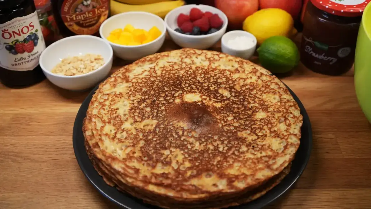 En h&ouml;g med gyllene pannkakor, redo f&ouml;r servering med sylt, frukt och n&ouml;tter. Ett perfekt pannkakor recept f&ouml;r en mysig frukost eller fika.