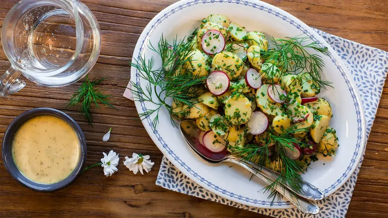 En h&auml;rlig hemmagjord potatissallad med r&auml;disor och dill, serverad med en kr&auml;mig dressing. Perfekt till sommarens grillkv&auml;llar!