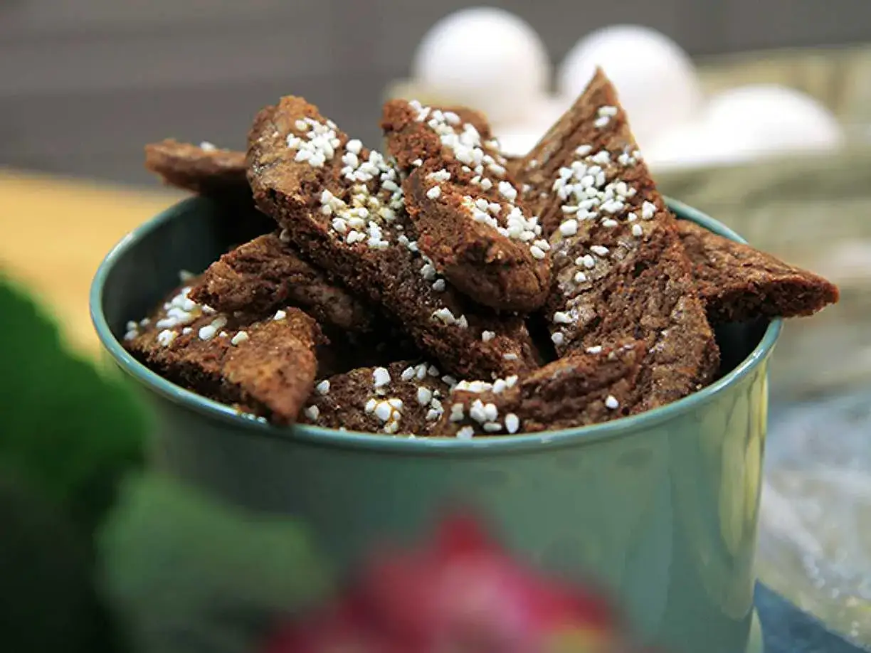 Chokladsnittar recept: Mörka, trekantiga småkakor med pärlsocker i en grön skål. Perfekt till fikat!