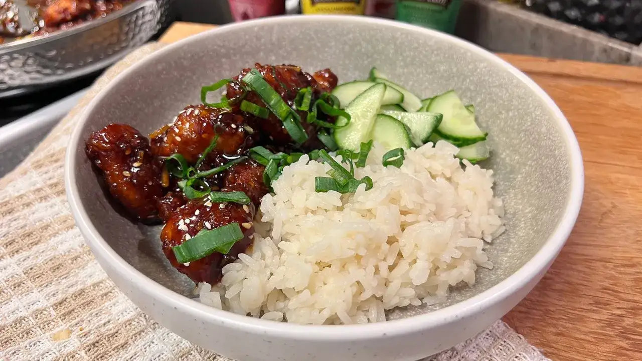 En sk&aring;l med kyckling och ris, toppad med gurka och salladsl&ouml;k. En l&auml;cker m&aring;ltid!
